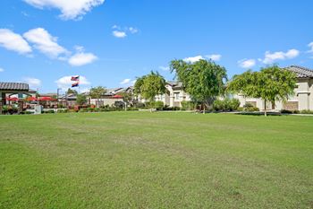 A large lawn with houses in the background